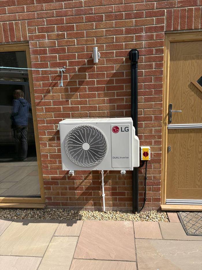 LG Dual Inverter air conditioning outdoor condenser unit installed on brick wall