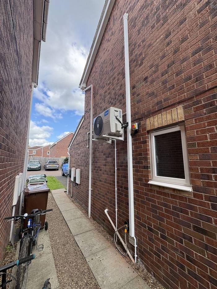 Midea air conditioning outdoor condenser unit installed on rear wall