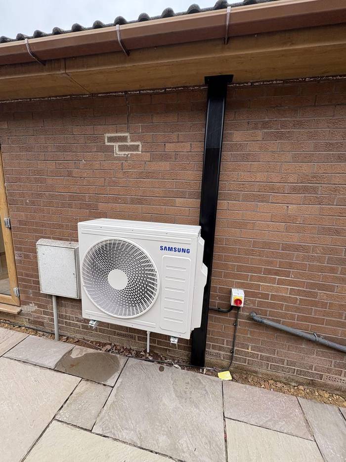 Samsung air conditioning outdoor condenser unit installed on brick wall